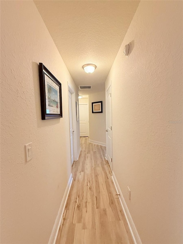 186 NW 44th St, Ocala, FL 34475 - hall with light wood-style flooring, a textured ceiling, and a textured wall