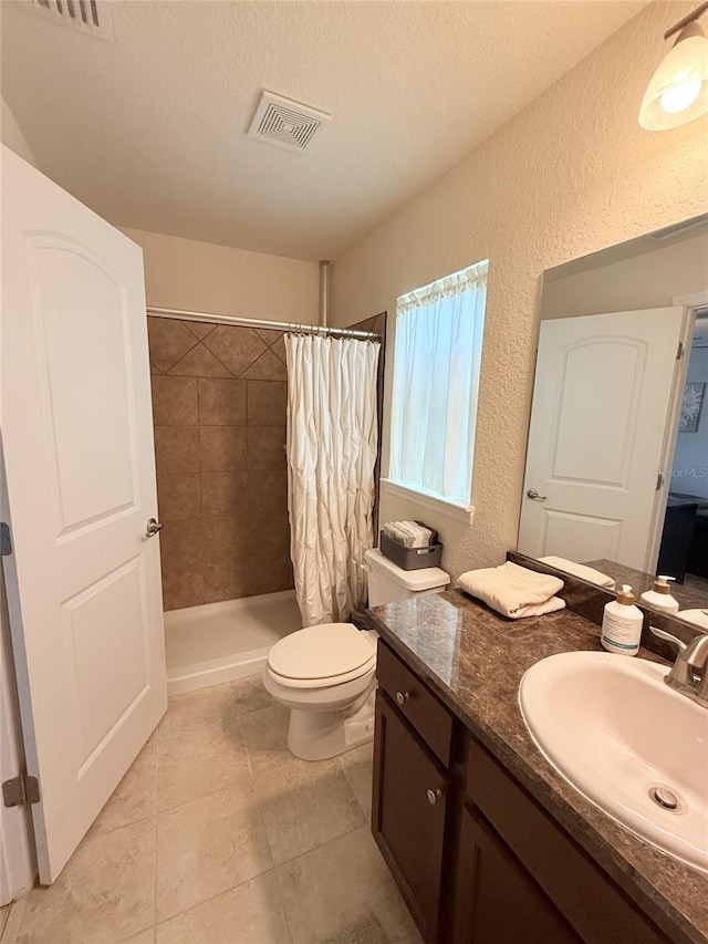186 NW 44th St, Ocala, FL 34475 - bathroom with vanity, a textured wall, tiled shower, tile patterned flooring, and a textured ceiling