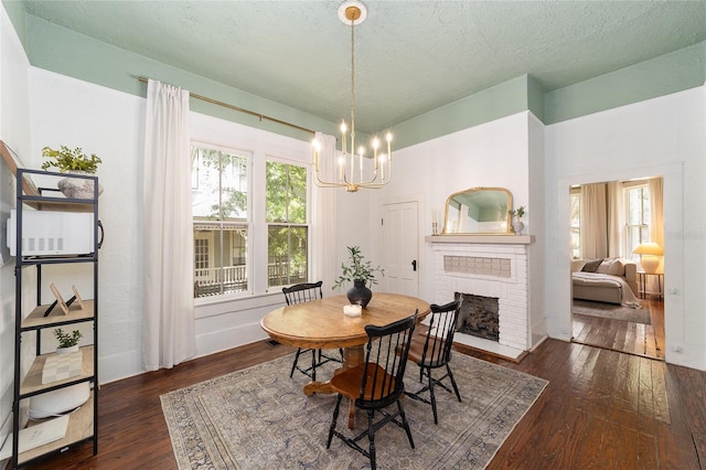 828 SE 3rd St, Ocala, FL 34471 - dining space featuring a chandelier, healthy amount of natural light, wood-type flooring, a brick fireplace, and a textured ceiling