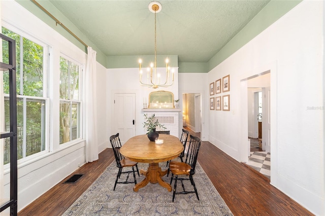 828 SE 3rd St, Ocala, FL 34471 - dining room with a chandelier, dark wood-type flooring, and baseboards