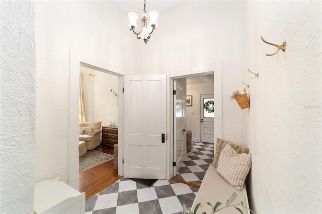 828 SE 3rd St, Ocala, FL 34471 - hall with tile patterned floors, a towering ceiling, a chandelier, and a textured wall