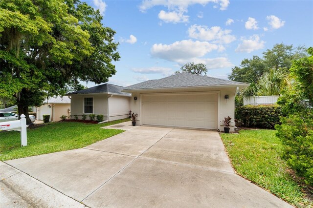 2644 SW 20th Cir, Ocala, FL 34471 - single story home with stucco siding, driveway, a front yard, a garage, and a shingled roof
