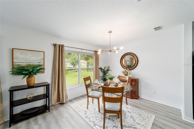 2644 SW 20th Cir, Ocala, FL 34471 - dining room featuring light wood finished floors, a chandelier, baseboards, and a textured ceiling
