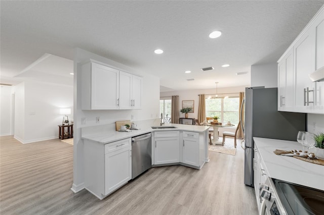 2644 SW 20th Cir, Ocala, FL 34471 - kitchen with dishwasher, a sink, light wood-style flooring, a peninsula, and white cabinets