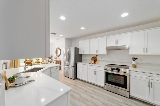 2644 SW 20th Cir, Ocala, FL 34471 - kitchen with appliances with stainless steel finishes, a sink, white cabinets, light countertops, and light wood finished floors