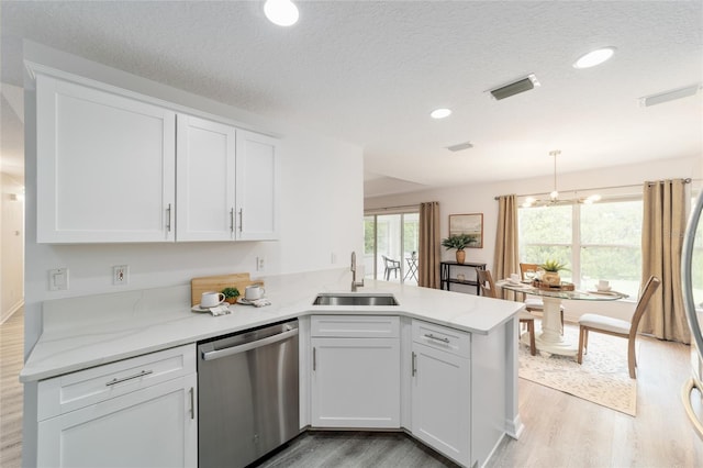 2644 SW 20th Cir, Ocala, FL 34471 - kitchen with dishwasher, a sink, light wood-style flooring, a peninsula, and white cabinets