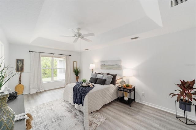 2644 SW 20th Cir, Ocala, FL 34471 - bedroom featuring a tray ceiling, wood finished floors, baseboards, and a ceiling fan