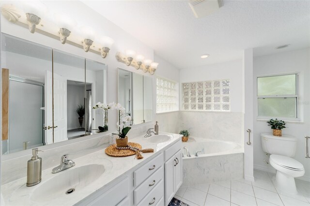 2644 SW 20th Cir, Ocala, FL 34471 - bathroom featuring a garden tub, double vanity, tile patterned flooring, toilet, and an enclosed shower