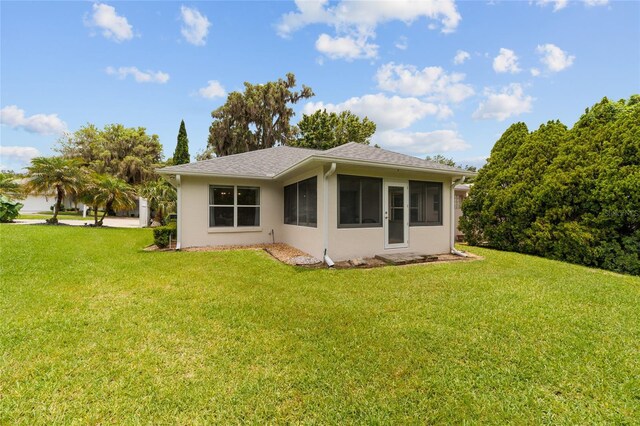 2644 SW 20th Cir, Ocala, FL 34471 - back of property with a lawn, a sunroom, and stucco siding