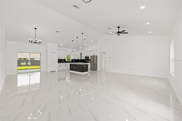 8456 SE 164th Pl, Summerfield, FL 34491 - unfurnished living room featuring high vaulted ceiling, ceiling fan, light marble finish floors, a chandelier, and recessed lighting