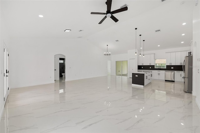 8456 SE 164th Pl, Summerfield, FL 34491 - unfurnished living room with ceiling fan, a sink, arched walkways, lofted ceiling, and a chandelier