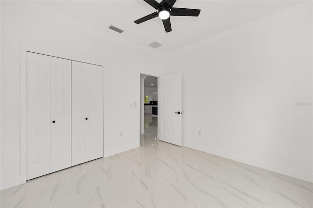 8456 SE 164th Pl, Summerfield, FL 34491 - unfurnished bedroom with marble look tile flooring, baseboards, a closet, and a ceiling fan