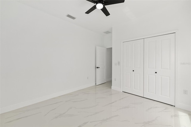 8456 SE 164th Pl, Summerfield, FL 34491 - unfurnished bedroom featuring light marble finish floors, baseboards, a closet, and a ceiling fan