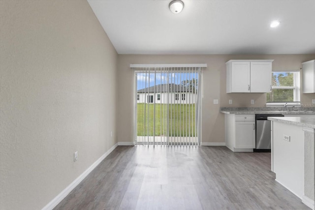 17277 SW 44th Cir, Ocala, FL 34473 - kitchen with stainless steel dishwasher, light countertops, light wood-type flooring, white cabinets, and recessed lighting