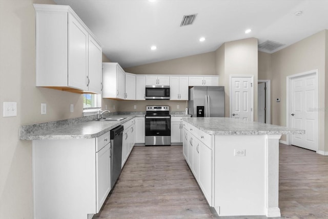 17277 SW 44th Cir, Ocala, FL 34473 - kitchen featuring appliances with stainless steel finishes, a center island, light wood-style floors, light countertops, and lofted ceiling