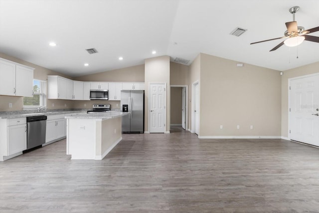 17277 SW 44th Cir, Ocala, FL 34473 - kitchen featuring stainless steel appliances, lofted ceiling, a kitchen island, ceiling fan, and white cabinets