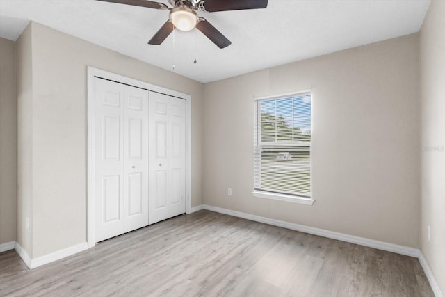 17277 SW 44th Cir, Ocala, FL 34473 - unfurnished bedroom featuring light wood finished floors, baseboards, a closet, and ceiling fan