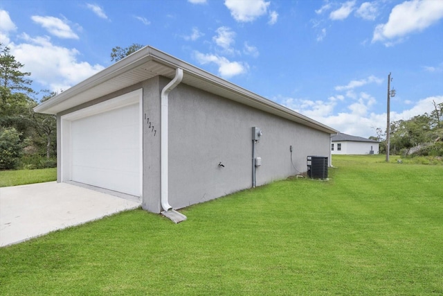 17277 SW 44th Cir, Ocala, FL 34473 - view of side of home with a garage, driveway, stucco siding, central air condition unit, and a yard