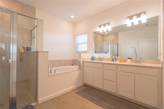 19551 SW 77th Loop, Dunnellon, FL 34432 - bathroom with a shower stall, double vanity, a bath, and wood finished floors
