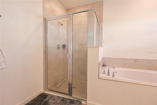 19551 SW 77th Loop, Dunnellon, FL 34432 - full bathroom with a shower stall, a bath, and baseboards