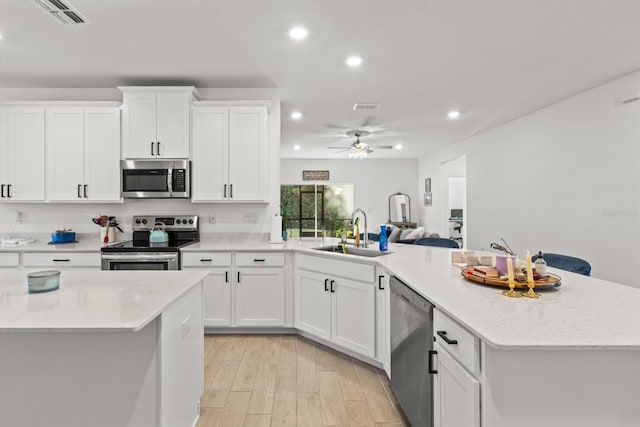 19551 SW 77th Loop, Dunnellon, FL 34432 - kitchen with appliances with stainless steel finishes, recessed lighting, a peninsula, white cabinets, and light wood-style flooring