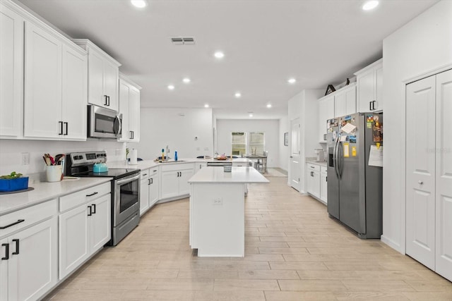 19551 SW 77th Loop, Dunnellon, FL 34432 - kitchen featuring stainless steel appliances, a center island, recessed lighting, light countertops, and white cabinets