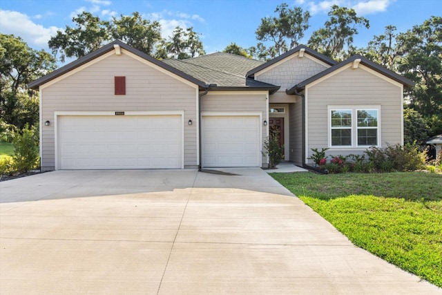 19551 SW 77th Loop, Dunnellon, FL 34432 - view of front of property with concrete driveway, an attached garage, and a front lawn