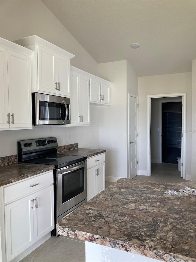 2 Pine Course Trl, Ocala, FL 34472 - kitchen with appliances with stainless steel finishes, white cabinetry, vaulted ceiling, and dark stone counters