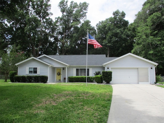 14192 SW 112th Cir, Dunnellon, FL 34432 - ranch-style house featuring a garage, driveway, a front lawn, and roof with shingles