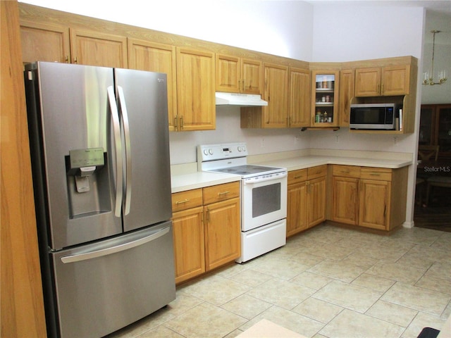 14192 SW 112th Cir, Dunnellon, FL 34432 - kitchen with appliances with stainless steel finishes, under cabinet range hood, light countertops, glass insert cabinets, and light tile patterned flooring