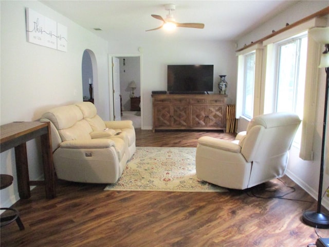 14192 SW 112th Cir, Dunnellon, FL 34432 - living room featuring arched walkways, a ceiling fan, dark wood-style floors, and baseboards