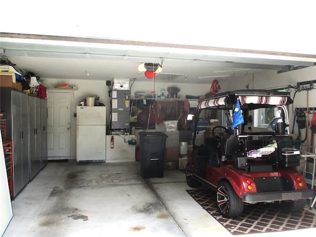 14192 SW 112th Cir, Dunnellon, FL 34432 - garage with freestanding refrigerator, heating unit, and a garage door opener