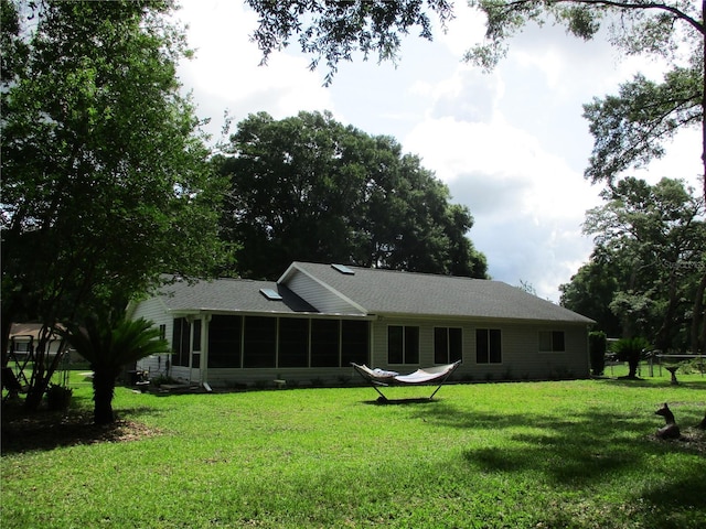 14192 SW 112th Cir, Dunnellon, FL 34432 - rear view of house with a sunroom, a yard, and roof with shingles