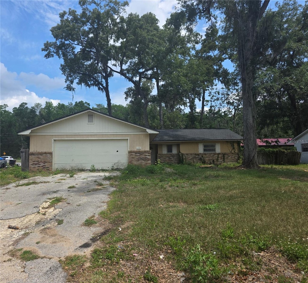 1751 SE 39th St, Ocala, FL 34480 - ranch-style house featuring driveway, an attached garage, stone siding, and brick siding