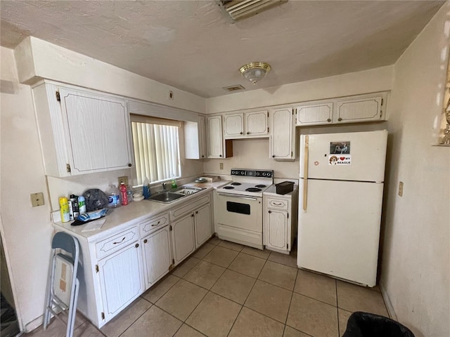 104 S Jeffery St, Beverly Hills, FL 34465 - kitchen featuring white appliances, a sink, light tile patterned floors, light countertops, and white cabinets