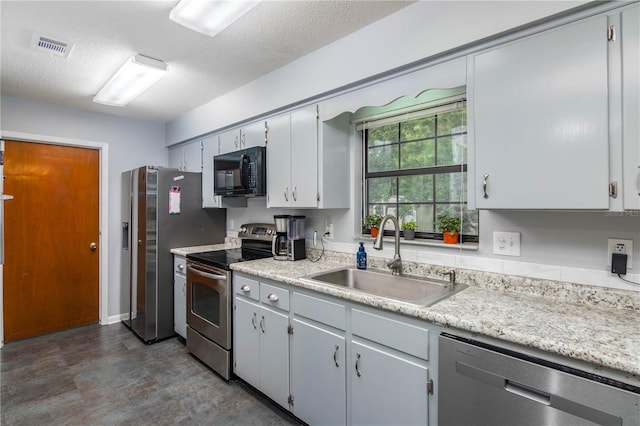 126 SW Mockingbird Way, Lake City, FL 32024 - kitchen with stainless steel appliances, a sink, light countertops, a textured ceiling, and gray cabinetry