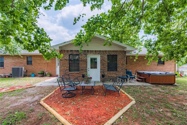 126 SW Mockingbird Way, Lake City, FL 32024 - rear view of house featuring a hot tub, a patio, central AC unit, and brick siding