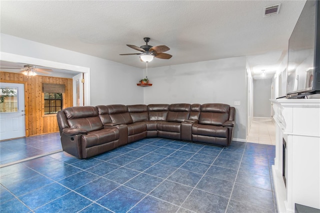 126 SW Mockingbird Way, Lake City, FL 32024 - living area with a ceiling fan, wood walls, dark tile patterned floors, a textured ceiling, and baseboards