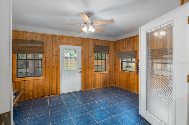 126 SW Mockingbird Way, Lake City, FL 32024 - foyer entrance with wooden walls, a ceiling fan, baseboards, and dark tile patterned flooring