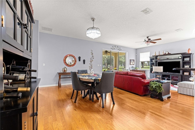 9551 SW 92nd Ter, Ocala, FL 34481 - dining space featuring light wood-type flooring, a textured ceiling, a ceiling fan, and baseboards