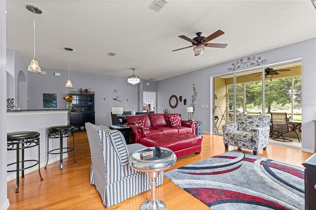 9551 SW 92nd Ter, Ocala, FL 34481 - living area with ceiling fan, light wood-type flooring, a textured ceiling, and arched walkways