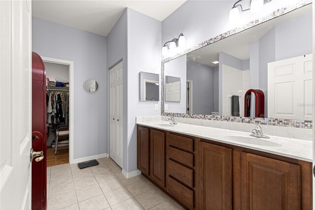 9551 SW 92nd Ter, Ocala, FL 34481 - full bathroom with double vanity, tile patterned floors, baseboards, a walk in closet, and a shower
