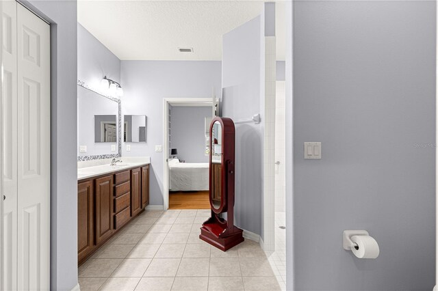 9551 SW 92nd Ter, Ocala, FL 34481 - ensuite bathroom featuring double vanity, tile patterned floors, a walk in shower, and baseboards