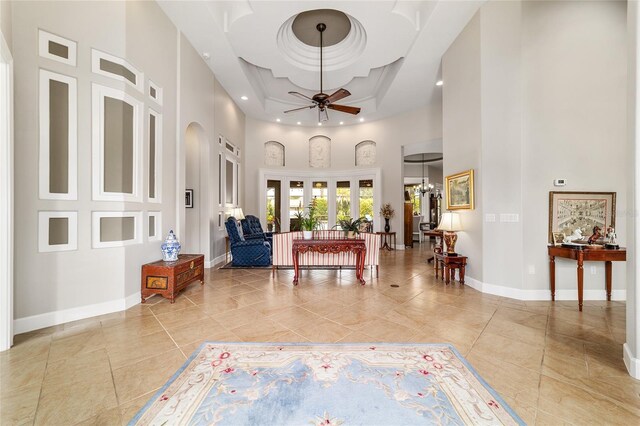 3986 SE 43rd Cir, Ocala, FL 34480 - living room featuring a high ceiling, ceiling fan, a chandelier, arched walkways, and a raised ceiling