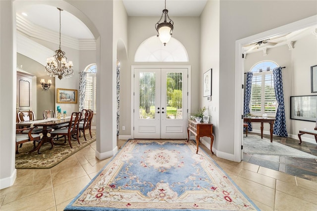 3986 SE 43rd Cir, Ocala, FL 34480 - tiled foyer featuring french doors, arched walkways, a chandelier, a towering ceiling, and ornamental molding