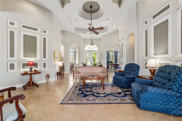 3986 SE 43rd Cir, Ocala, FL 34480 - living room with arched walkways, a towering ceiling, a raised ceiling, light tile patterned flooring, and ceiling fan