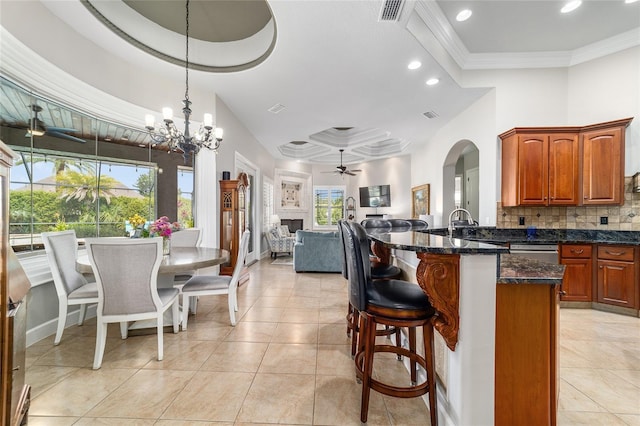 3986 SE 43rd Cir, Ocala, FL 34480 - kitchen featuring a ceiling fan, open floor plan, a kitchen breakfast bar, tasteful backsplash, and arched walkways