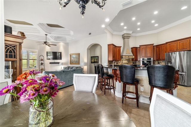 3986 SE 43rd Cir, Ocala, FL 34480 - kitchen with stainless steel appliances, arched walkways, crown molding, custom range hood, and backsplash