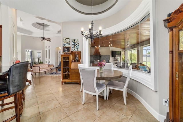 3986 SE 43rd Cir, Ocala, FL 34480 - dining area featuring a chandelier, ceiling fan, a tray ceiling, light tile patterned floors, and a high ceiling
