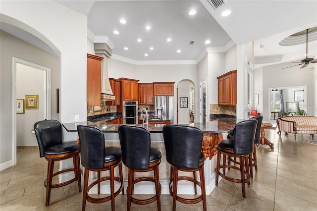 3986 SE 43rd Cir, Ocala, FL 34480 - kitchen with stainless steel appliances, arched walkways, a peninsula, backsplash, and recessed lighting